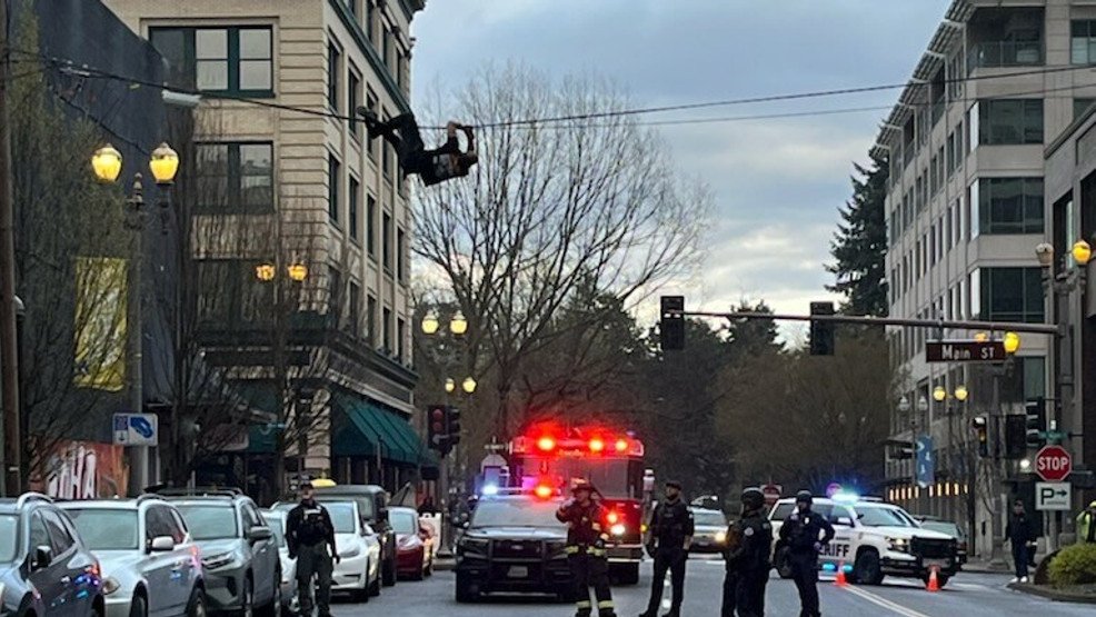 Man throws debris, precariously perches on wires before falling on fire truck in Vancouver - KATU